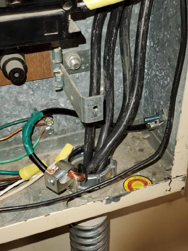 Old fuse box and disconnects on a basement wall before an upgrade